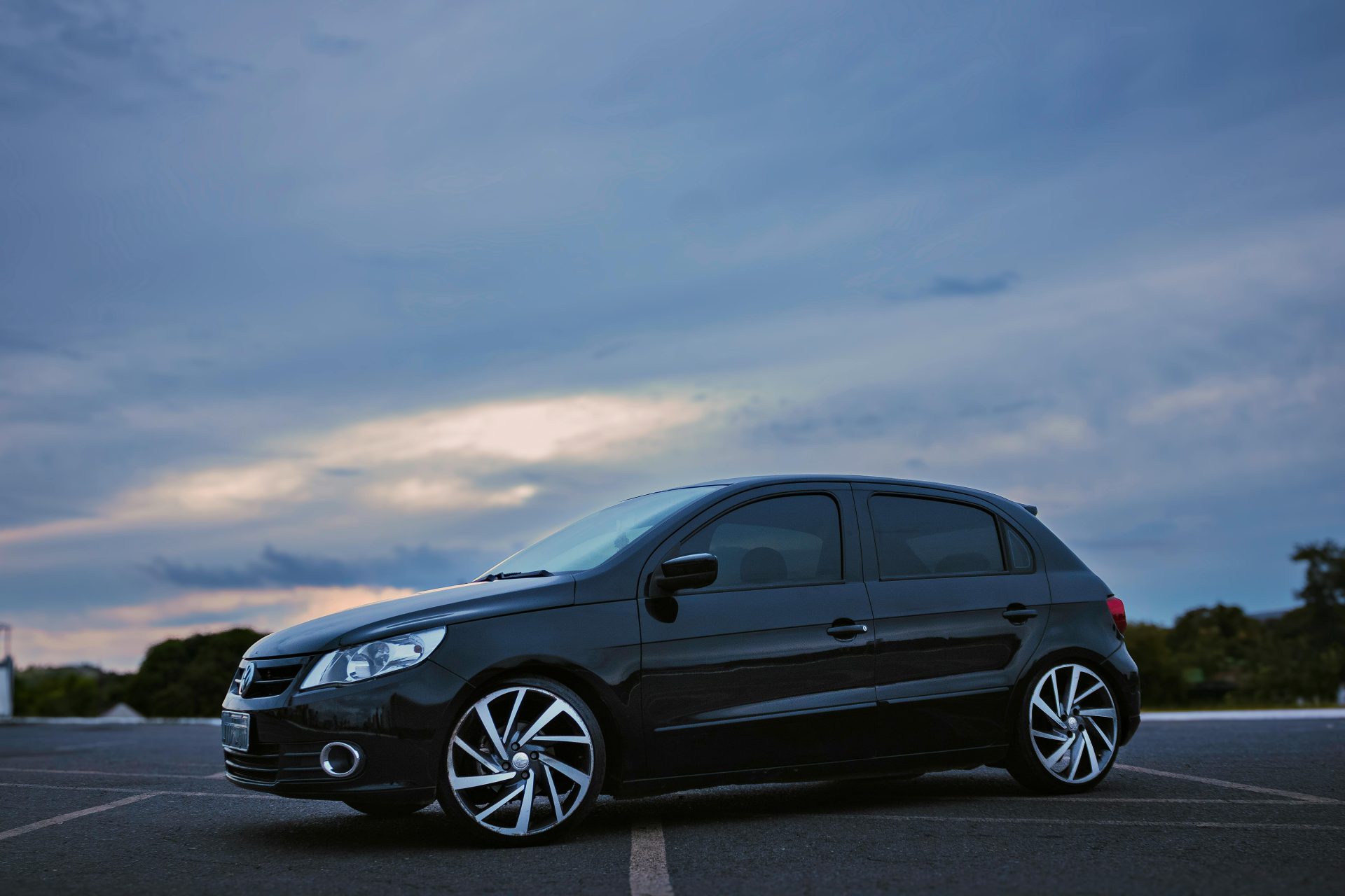 Un elegante hatchback negro estacionado en Brasilia al crepúsculo, con un cielo dramático de fondo.