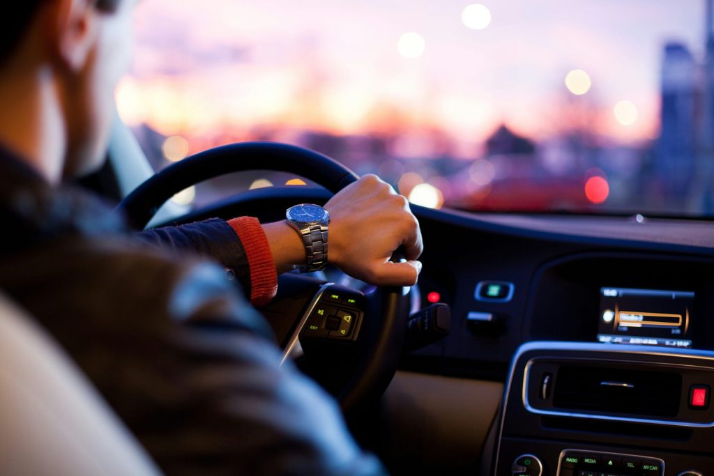 Hombre conduciendo un coche y llevando un reloj de pulsera.